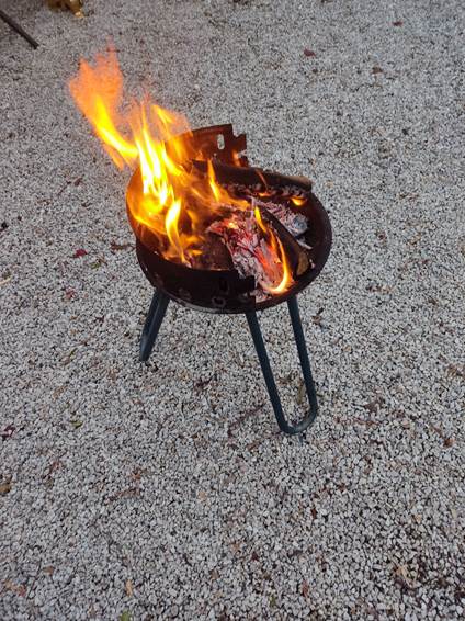 A fire burning in a barbecue

Description automatically generated