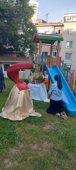 A nun kneeling next to a slide

Description automatically generated