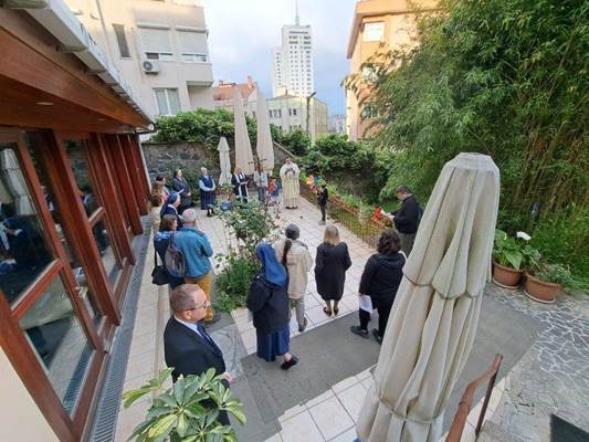 A group of people standing in a courtyard

Description automatically generated