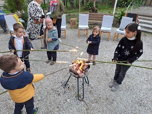 A group of children roasting marshmallows over a fire

Description automatically generated