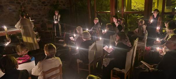 A group of people sitting in chairs with candles in their hands

Description automatically generated