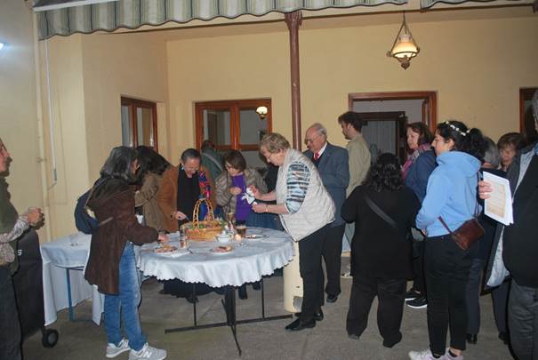 A group of people standing around a table

Description automatically generated