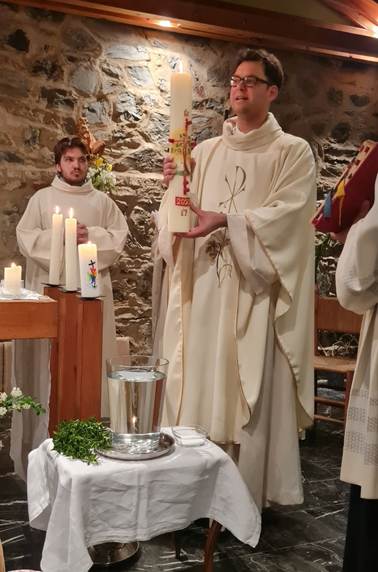 A person in white robes holding a candle

AI-generated content may be incorrect.
