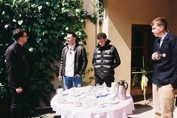 A couple of men standing outside a table

AI-generated content may be incorrect.