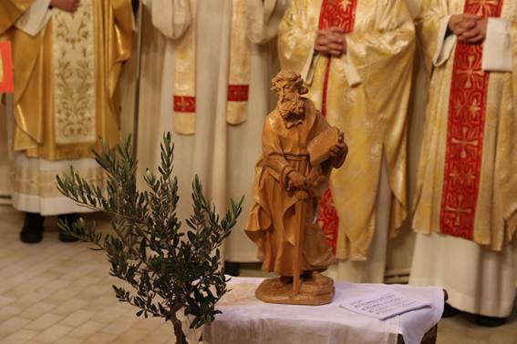 A statue of a person with a stick and a tree

AI-generated content may be incorrect.