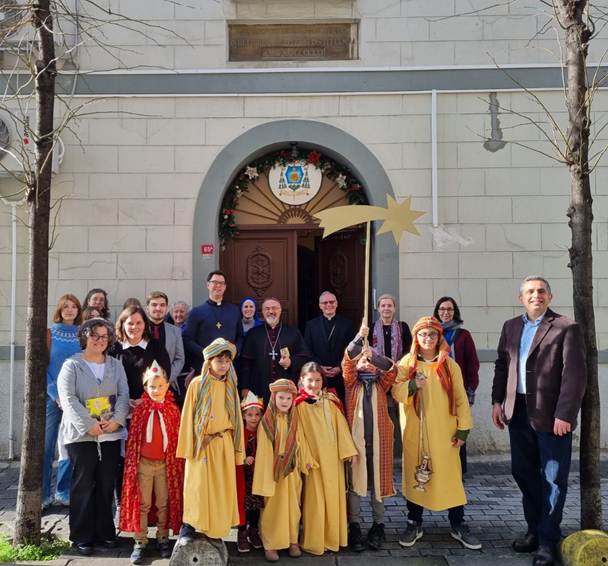 A group of people standing in front of a building

Description automatically generated